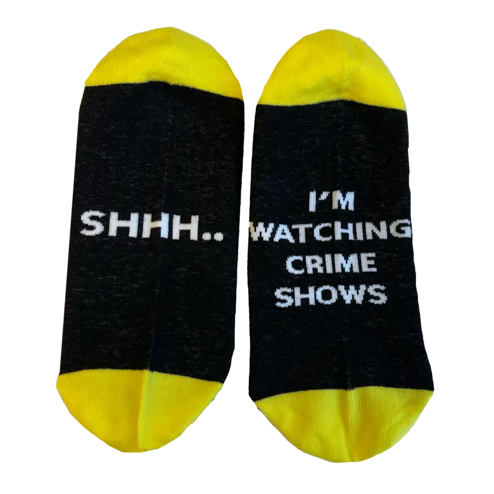 Pair of black and yellow socks with text about watching crime shows.