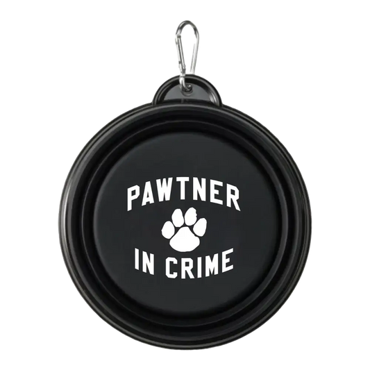 Collapsible black pet bowl with ’Pawtner in Crime’ and a paw print printed on it.